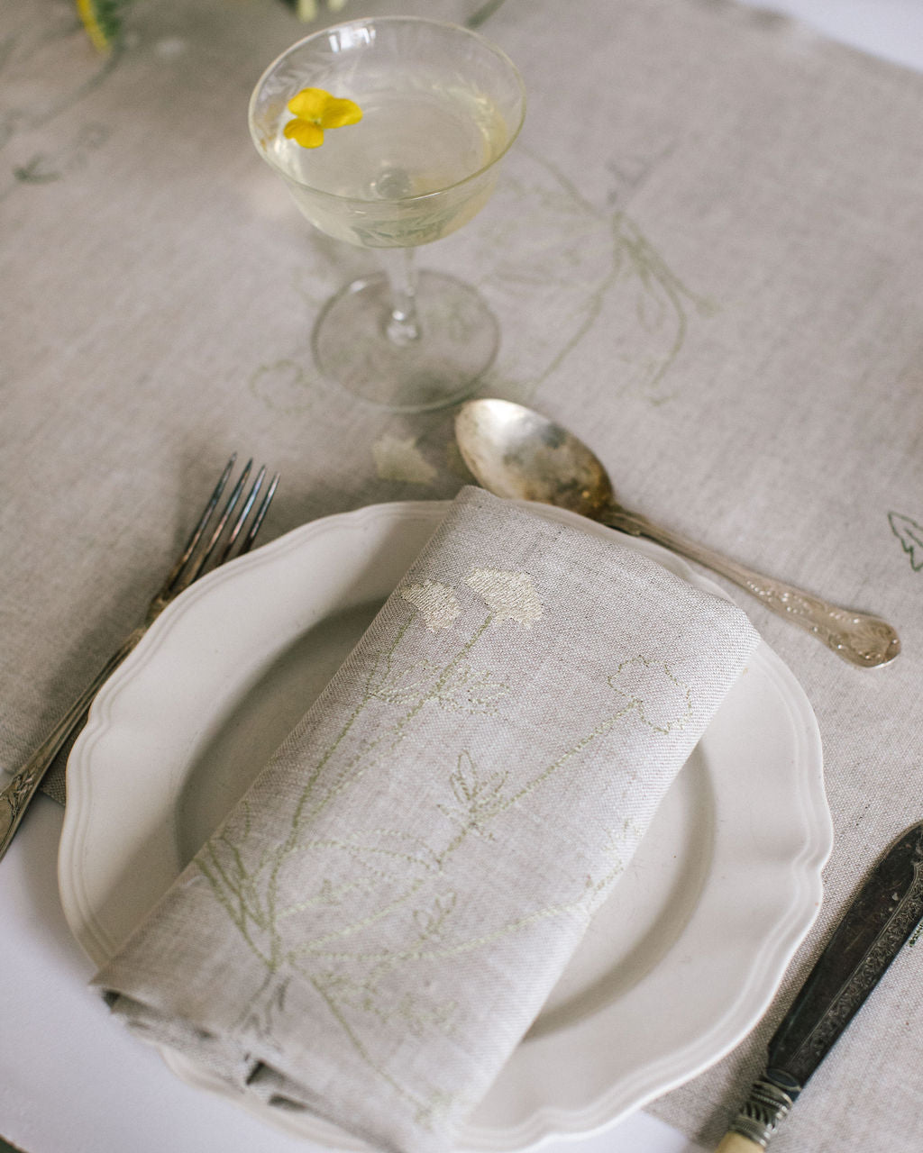 Natural Irish linen napkin with subtle embroidery of a plant