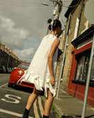 Just above knee length Irish linen A linen dress, with cover buttons along the centre back, a deep hem and appliqué bows.