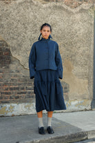 Navy irish linen skirt in midi length with a deep hem, frill detail along the seam and appliqué bows 