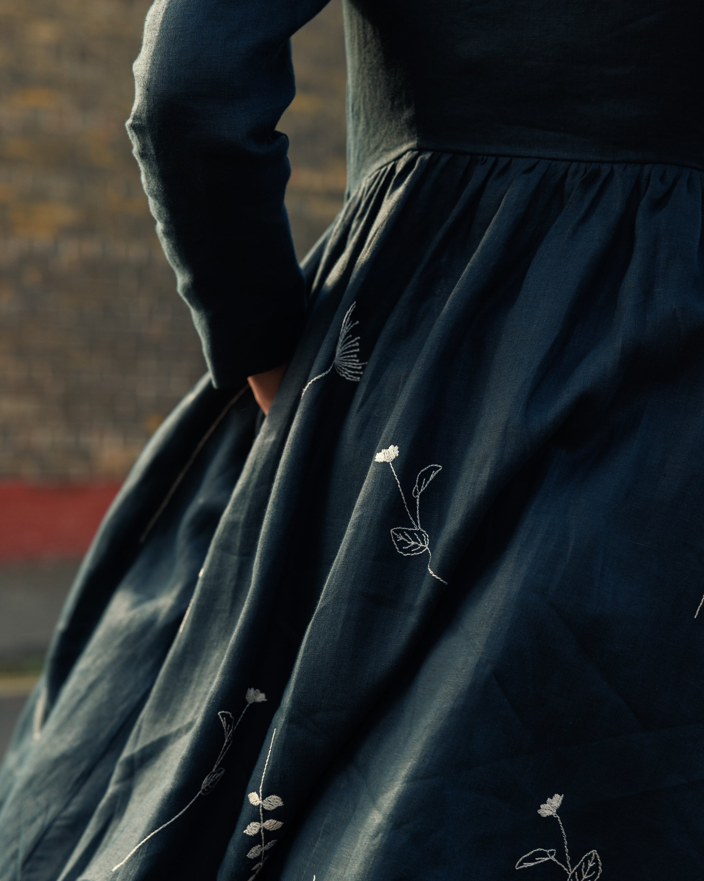 long sleeve irish linen dress in navy with a fitted bodice and ivory wildflower embroidery on skirt 