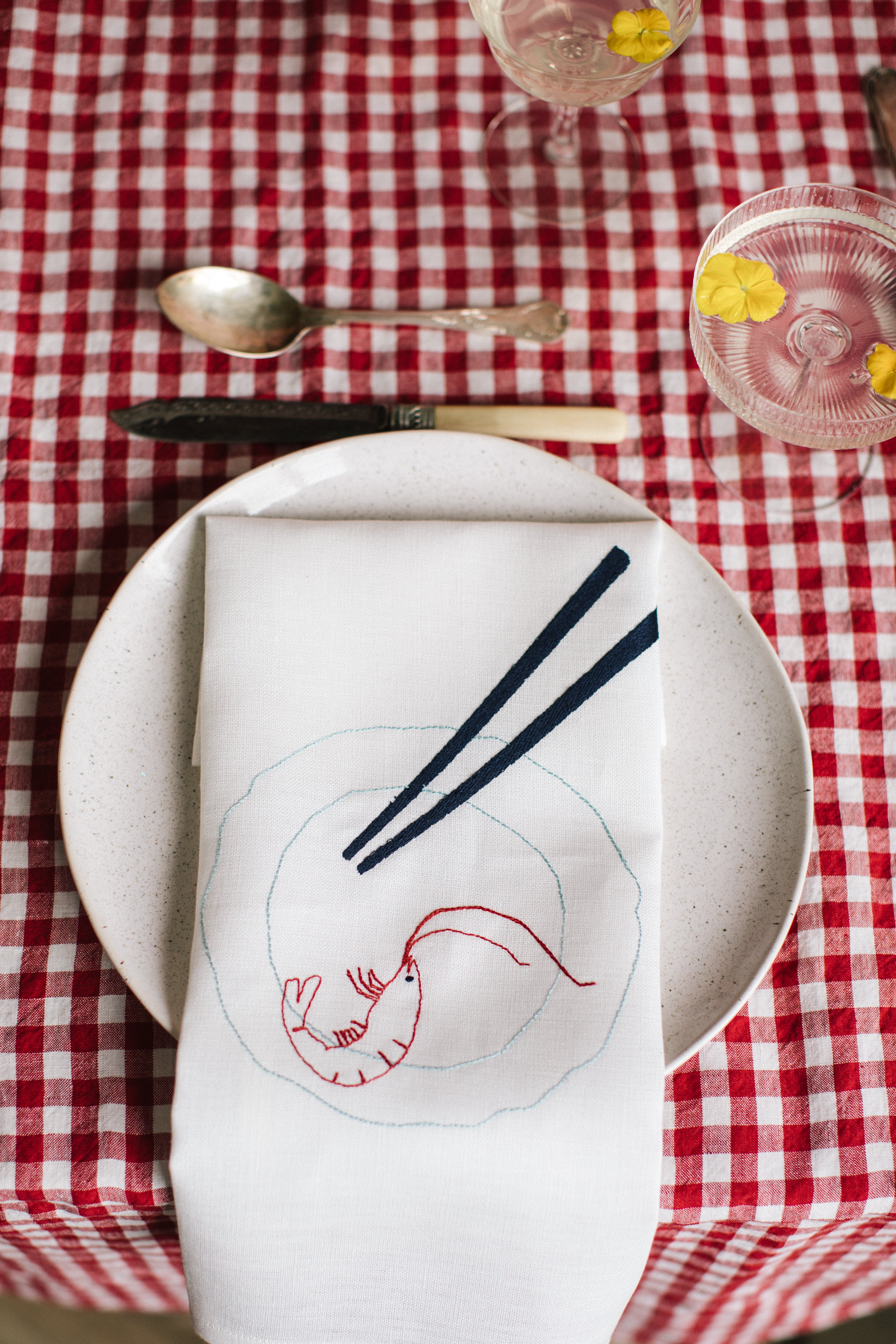 Irish linen napkin with embroidery of chopsticks and a shrimp on a plate 