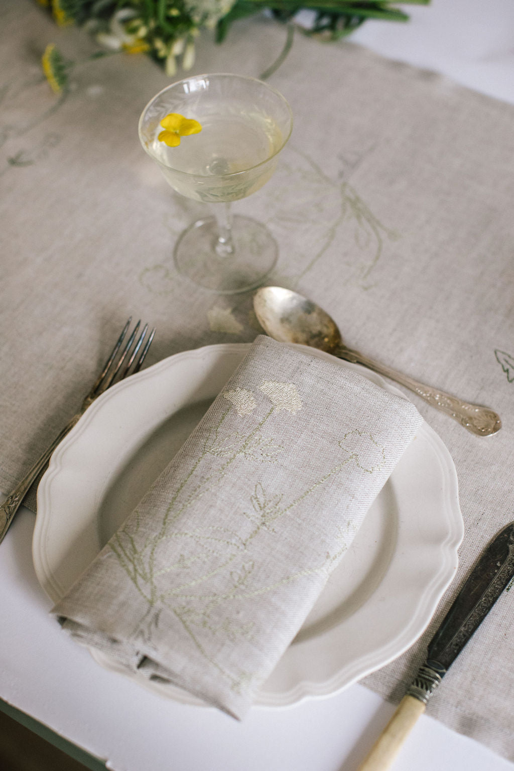 Natural Irish linen napkin with subtle embroidery of a plant 