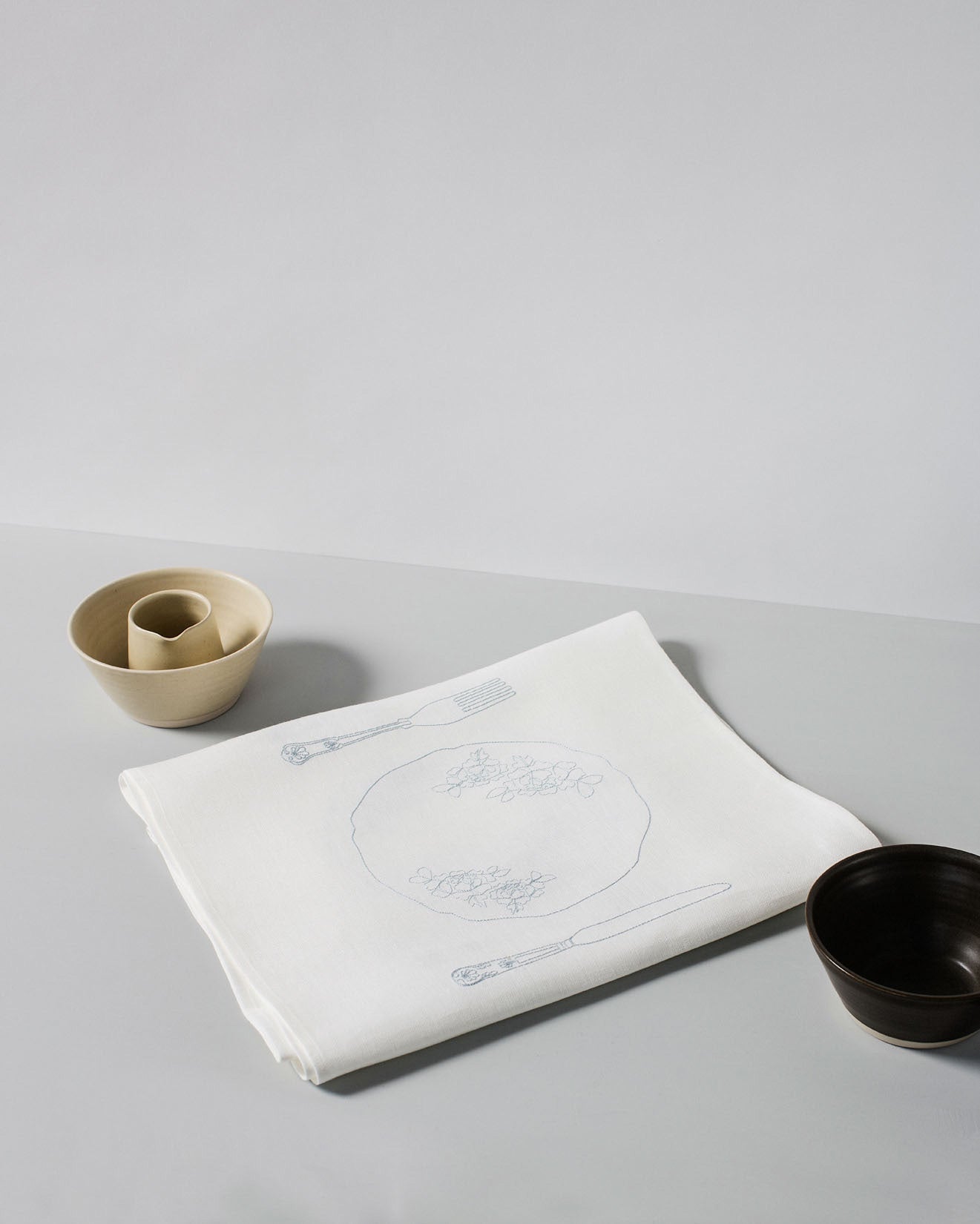 Irish linen tablerunner with powder blue embroidery of a knife, fork and plate 