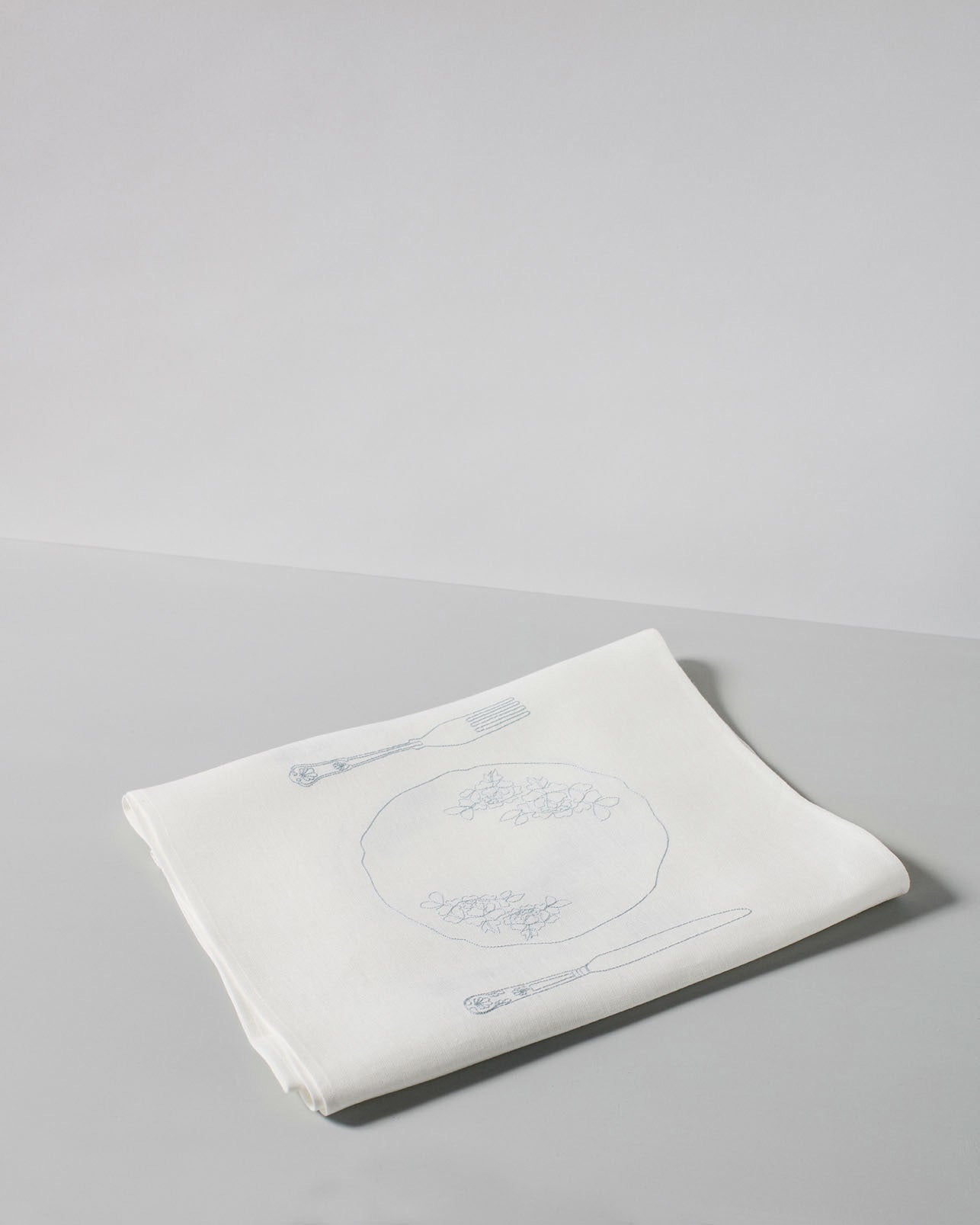 Irish linen tablerunner with powder blue embroidery of a table setting 