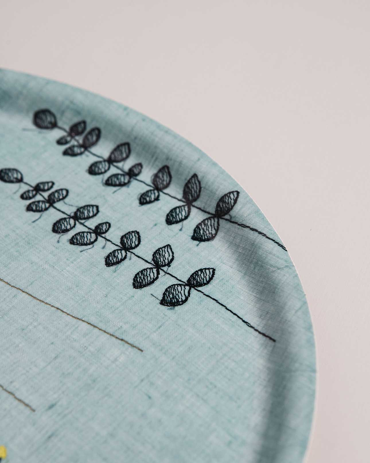 Close up of Irish wildflower embroidery on light blue Irish linen tray 